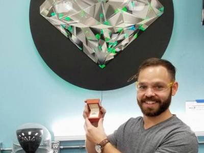 Guy who built an engagement ring in a DIY workshop holding his ring