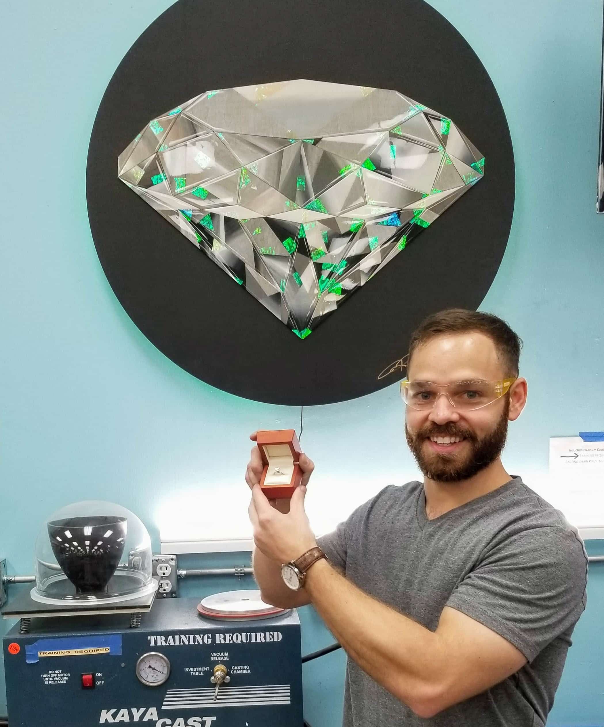 Guy who built an engagement ring in a DIY workshop holding his ring