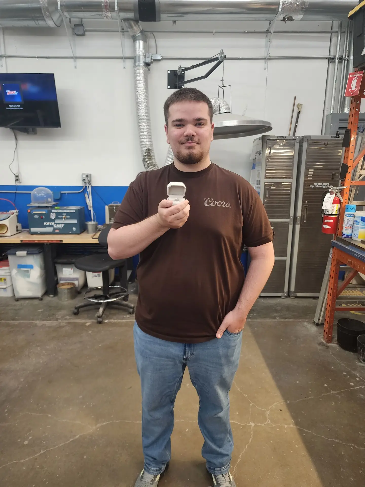 Proud maker holding his finished handmade engagement ring at the LaProng jewelry workshop studio near Dallas