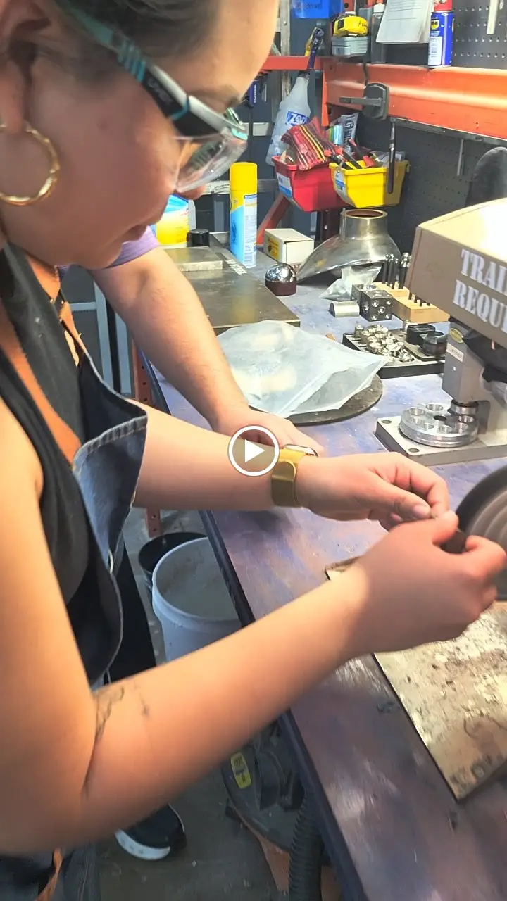 Hands hammering a gold ring blank on the jewelers bench at the LaProng DIY ring making workshop