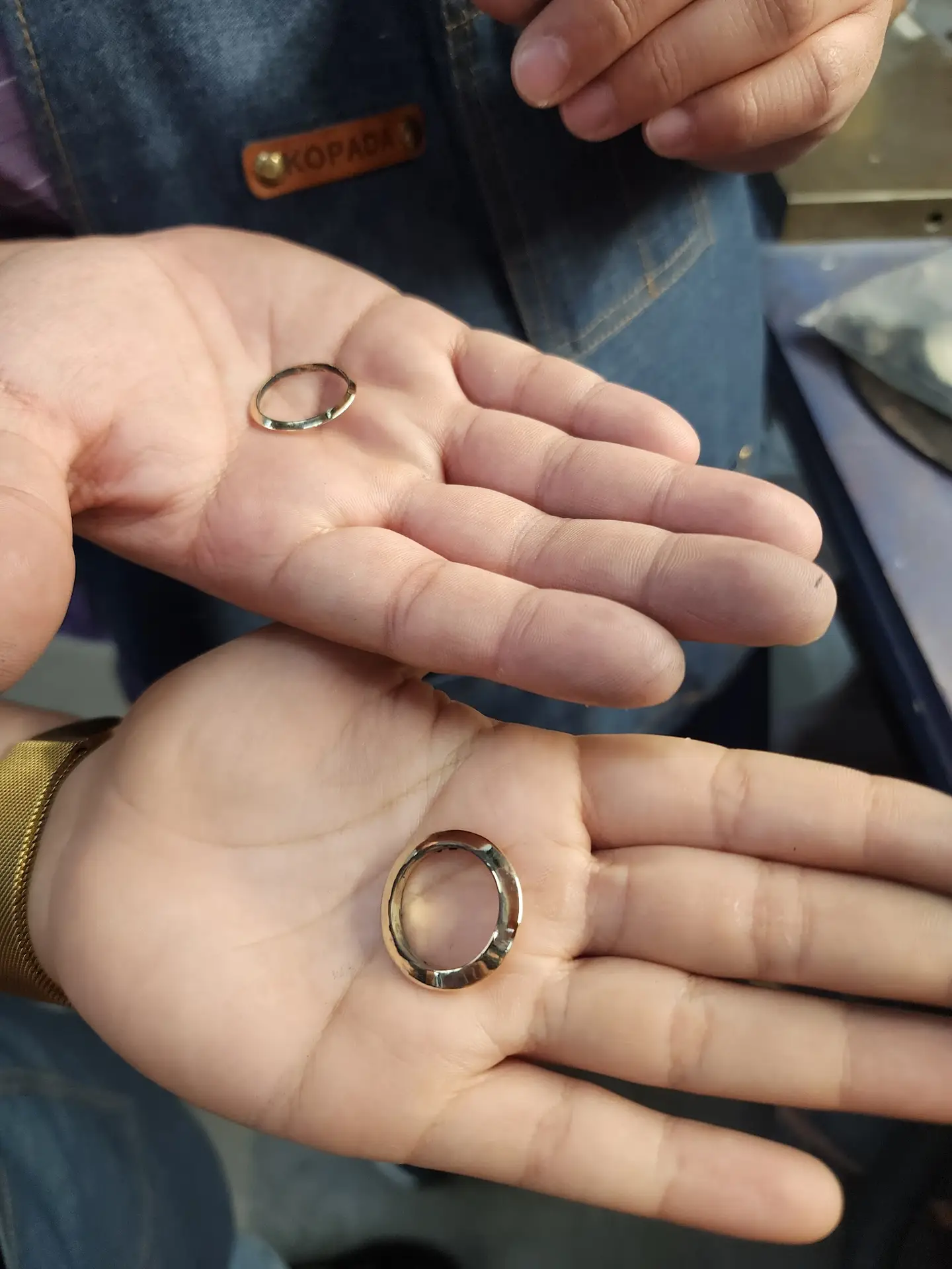 Couple holding the finished wedding bands they made by hand at the LaProng make your own wedding ring workshop