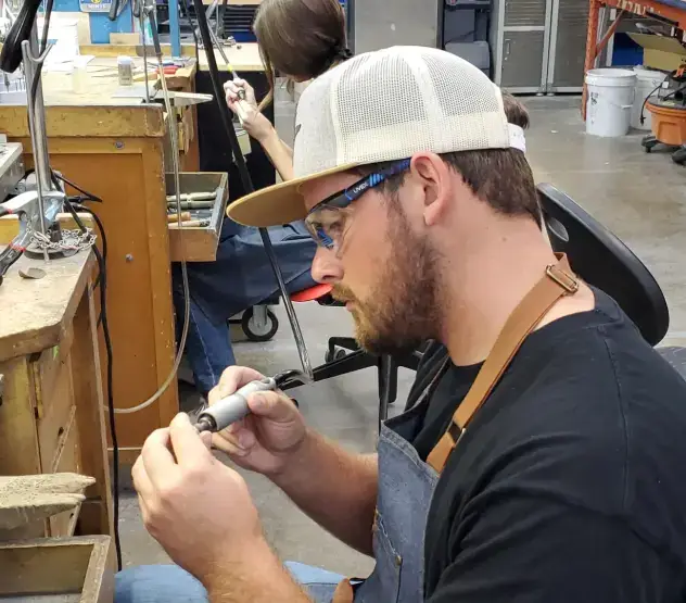 Workshop guest polishing his handmade engagement ring at the bench