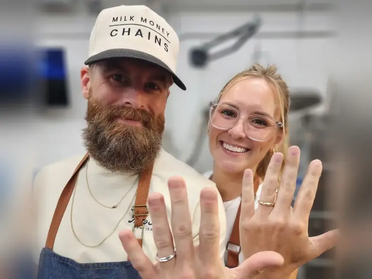 Couple smiling and showing the wedding rings they made for each other at a LaProng Jewelers workshop in Dallas