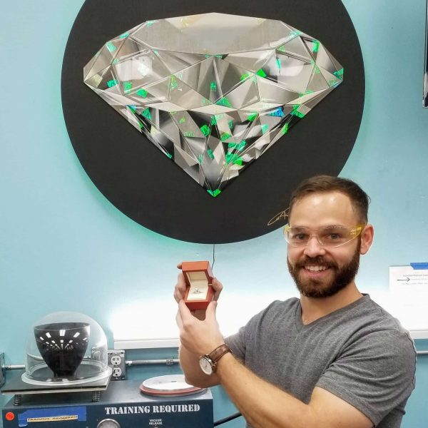 Guy who built an engagement ring in a DIY workshop holding his ring